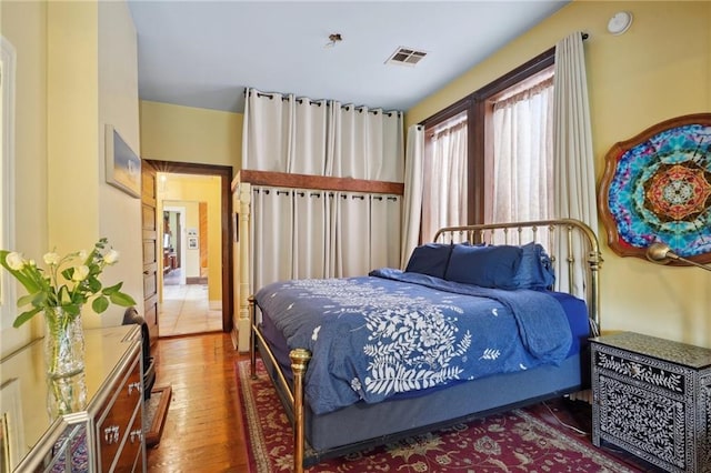 bedroom featuring wood finished floors and visible vents