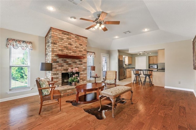 4740 W Esplanade Ave, Metairie, LA 70006 - living room with light wood finished floors, baseboards, visible vents, a ceiling fan, and a fireplace