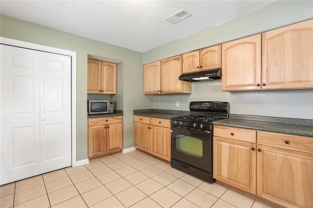 4740 W Esplanade Ave, Metairie, LA 70006 - kitchen with light brown cabinets, dark countertops, stainless steel microwave, under cabinet range hood, and black gas range