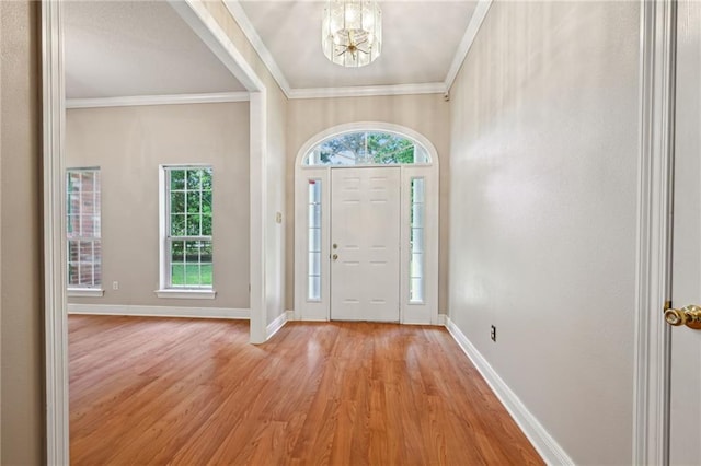 4761 Sharp Rd, Mandeville, LA 70471 - foyer entrance with light wood-style flooring, a chandelier, ornamental molding, and plenty of natural light