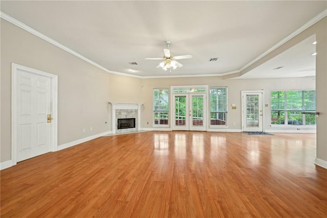 4761 Sharp Rd, Mandeville, LA 70471 - unfurnished living room featuring a ceiling fan, healthy amount of natural light, light wood-style floors, ornamental molding, and a premium fireplace
