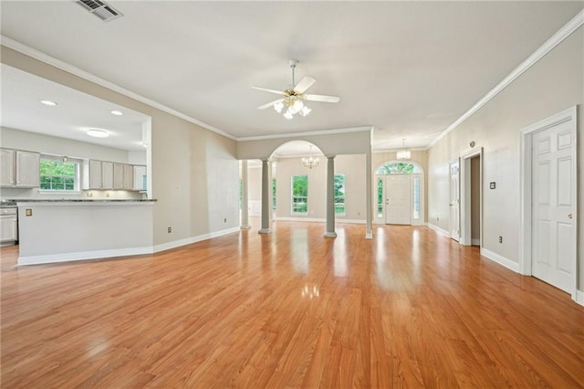 4761 Sharp Rd, Mandeville, LA 70471 - unfurnished living room featuring decorative columns, a ceiling fan, light wood finished floors, crown molding, and a chandelier