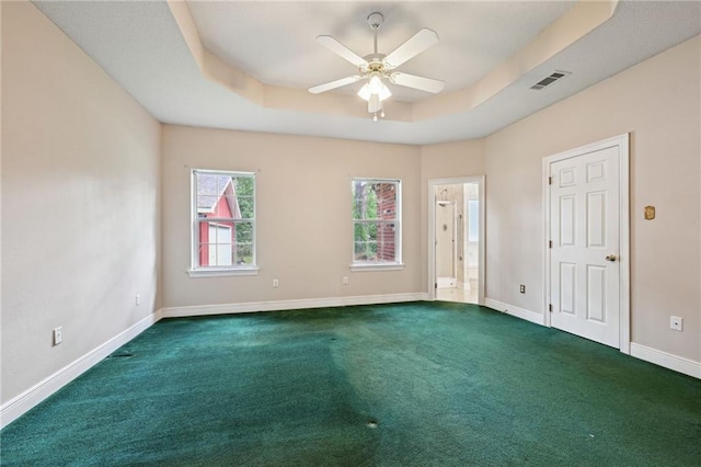 4761 Sharp Rd, Mandeville, LA 70471 - spare room featuring dark colored carpet, a tray ceiling, and ceiling fan