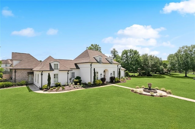 exterior space featuring stucco siding and a front yard