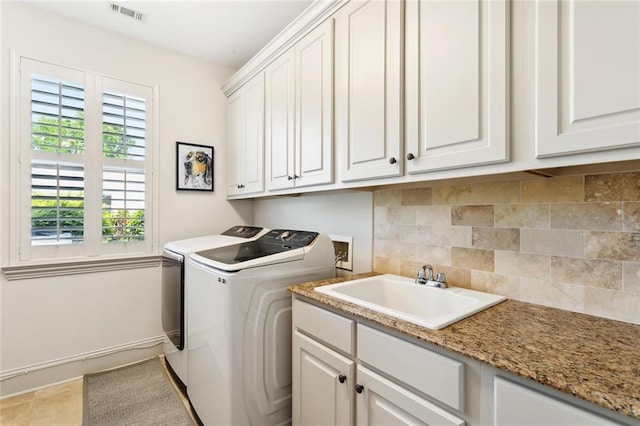 laundry room featuring a sink, cabinet space, washer and clothes dryer, visible vents, and baseboards