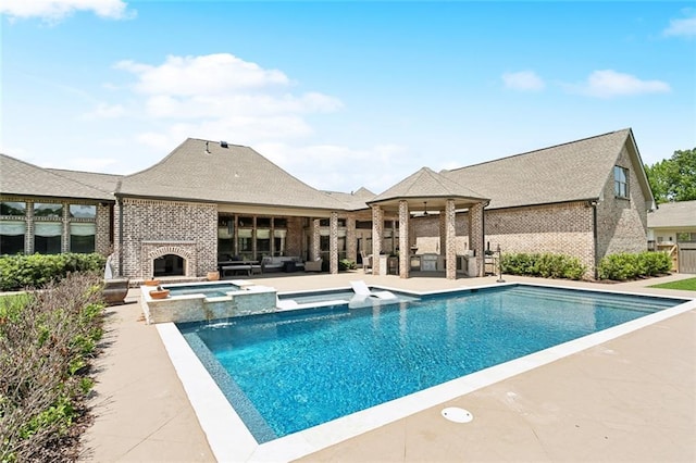 view of pool featuring an outdoor living space with a fireplace, a pool with connected hot tub, and a patio area
