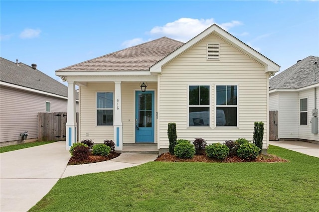 bungalow featuring concrete driveway, a shingled roof, covered porch, a front yard, and fence