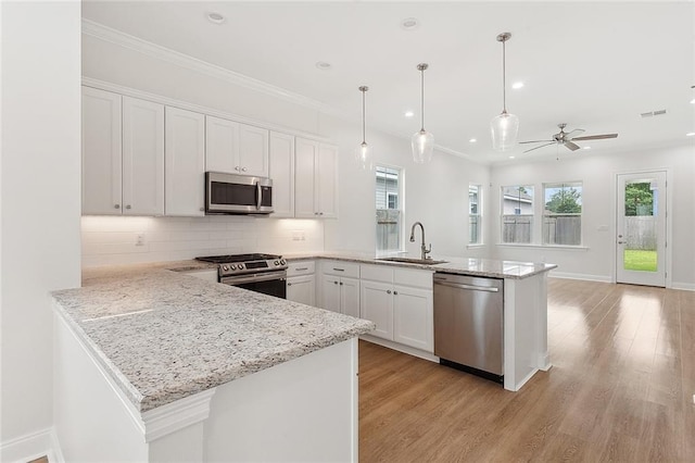 kitchen with a sink, stainless steel appliances, visible vents, a peninsula, and white cabinetry