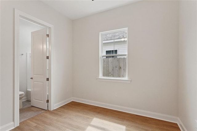 unfurnished room featuring light wood finished floors and baseboards