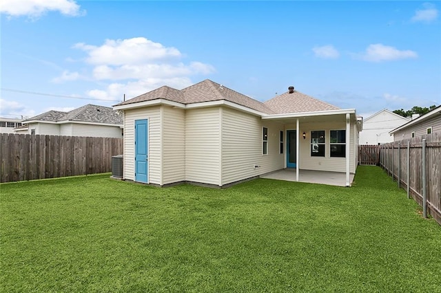 back of property with a yard, central air condition unit, a patio, and a fenced backyard