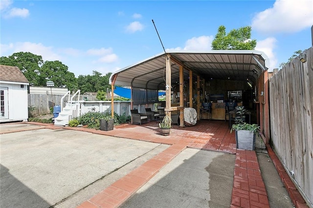 view of parking with fence and a carport