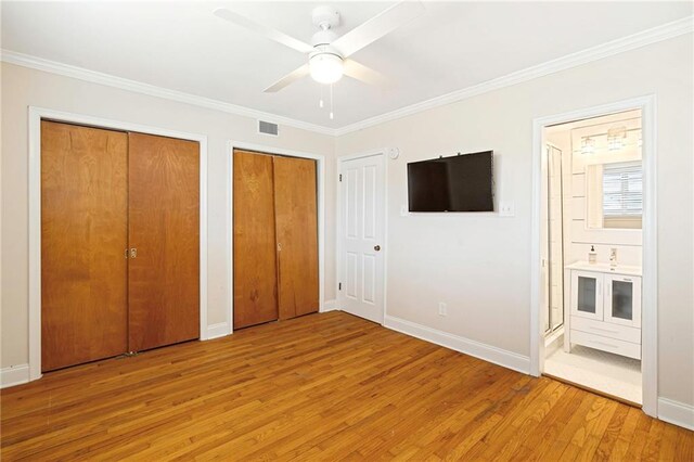 1508 Eisenhower Ave, Metairie, LA 70003 - unfurnished bedroom with multiple closets, visible vents, ornamental molding, and light wood-style flooring