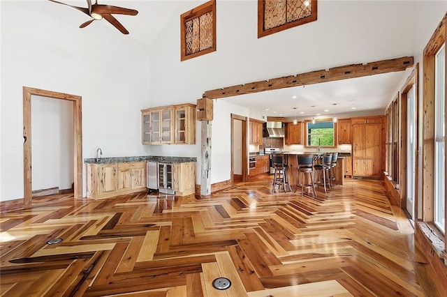 living area featuring baseboards, a ceiling fan, and high vaulted ceiling