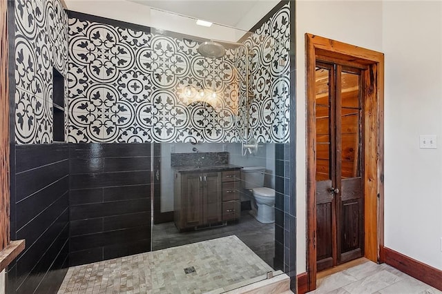 bathroom featuring baseboards, toilet, vanity, and a shower