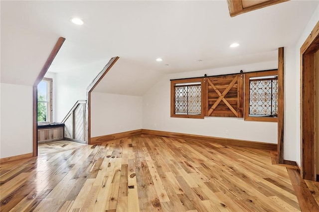 additional living space with recessed lighting, vaulted ceiling, light wood-style flooring, and baseboards
