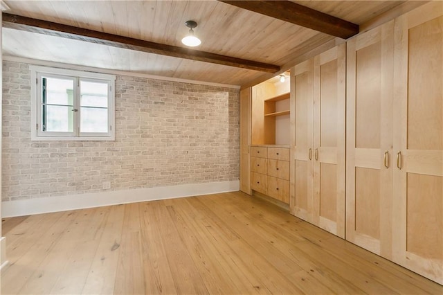 additional living space with wooden ceiling, beam ceiling, baseboards, brick wall, and light wood finished floors