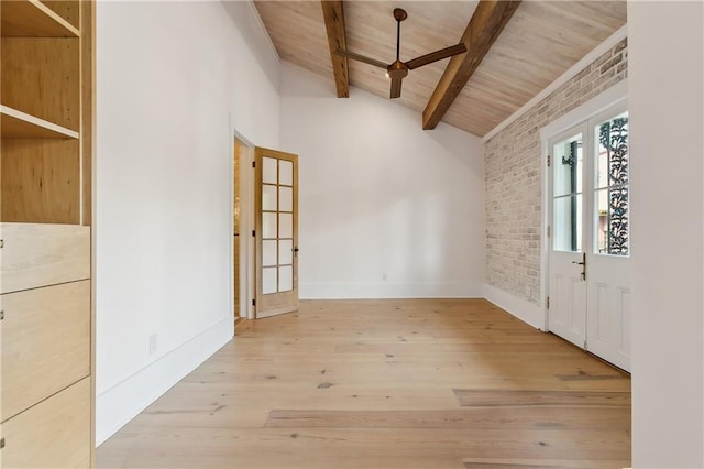 empty room with wooden ceiling, lofted ceiling with beams, wood finished floors, brick wall, and baseboards