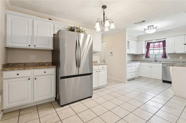 kitchen featuring stainless steel appliances, ornamental molding, white cabinets, pendant lighting, and a chandelier