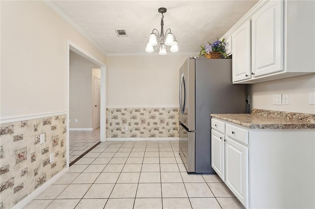 kitchen featuring a chandelier, white cabinets, wallpapered walls, crown molding, and freestanding refrigerator