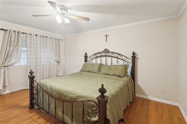 bedroom with wood finished floors, baseboards, crown molding, and ceiling fan
