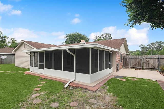 rear view of house with a sunroom, a gate, and a shingled roof