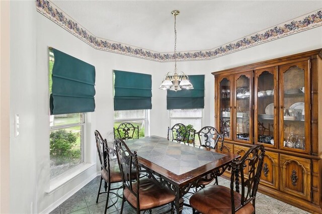 dining space with baseboards, an inviting chandelier, tile patterned flooring, and plenty of natural light