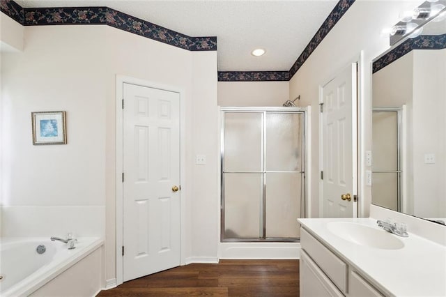 full bathroom featuring a bath, wood finished floors, vanity, and a stall shower