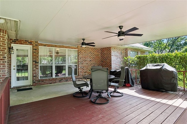 wooden terrace featuring a ceiling fan, outdoor dining space, and area for grilling
