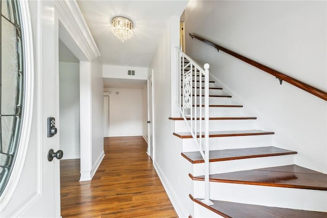 2121 Mediamolle Dr, New Orleans, LA 70114 - stairway featuring wood finished floors, baseboards, and a chandelier