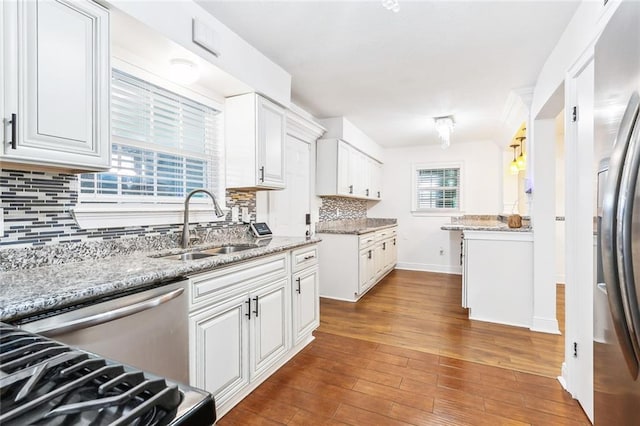 2121 Mediamolle Dr, New Orleans, LA 70114 - kitchen with a sink, white cabinets, wood finished floors, decorative backsplash, and baseboards