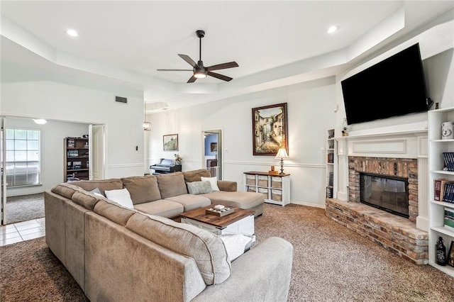 1229 Hampton Ct, Slidell, LA 70460 - carpeted living area featuring a ceiling fan, a brick fireplace, visible vents, and a raised ceiling