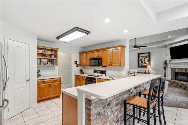 1229 Hampton Ct, Slidell, LA 70460 - kitchen featuring a kitchen breakfast bar, open floor plan, gas range, black microwave, and light tile patterned floors