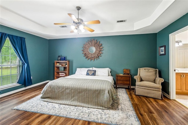 1229 Hampton Ct, Slidell, LA 70460 - bedroom featuring a tray ceiling, wood finished floors, and visible vents