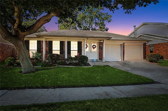 ranch-style home featuring concrete driveway, a lawn, and an attached garage