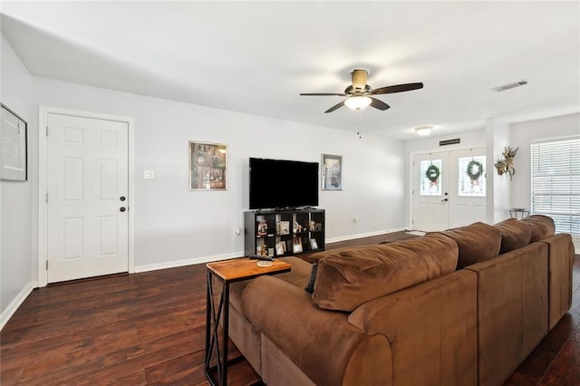 living room featuring baseboards, visible vents, ceiling fan, and dark wood-type flooring