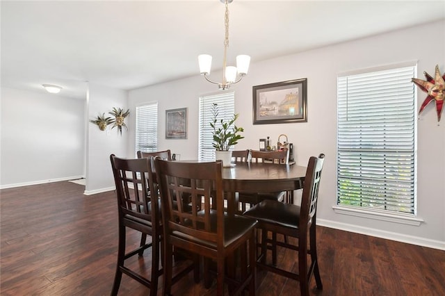 dining area featuring baseboards, a wealth of natural light, an inviting chandelier, and dark wood-type flooring