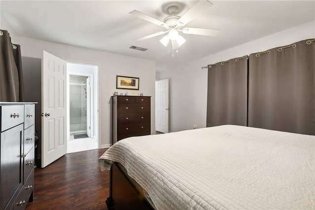 bedroom with visible vents, a ceiling fan, ensuite bath, and dark wood-type flooring