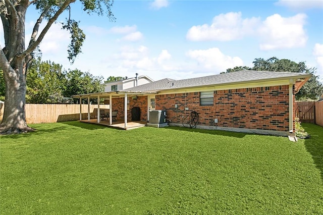 back of property featuring a patio, brick siding, a fenced backyard, and a yard