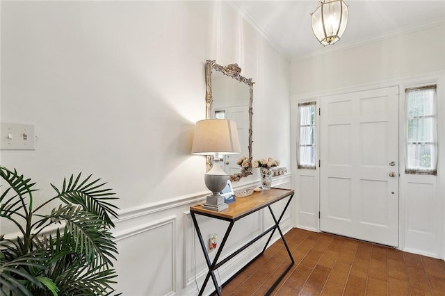 entrance foyer with crown molding and wood finished floors