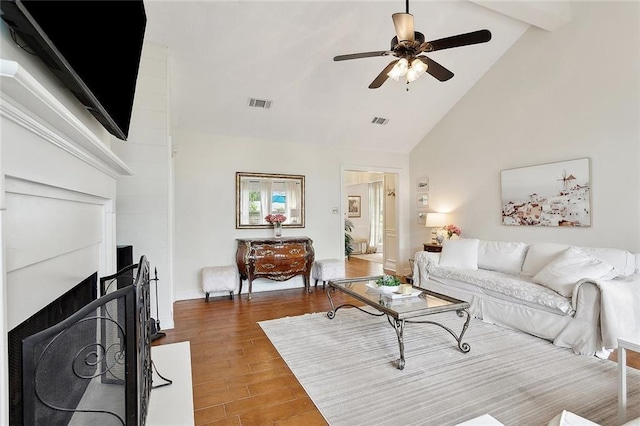 living room featuring high vaulted ceiling, ceiling fan, wood finished floors, and visible vents