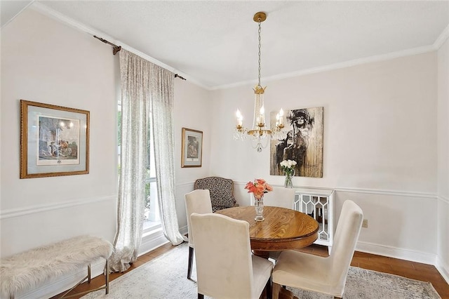 dining room featuring baseboards, wood finished floors, an inviting chandelier, and ornamental molding