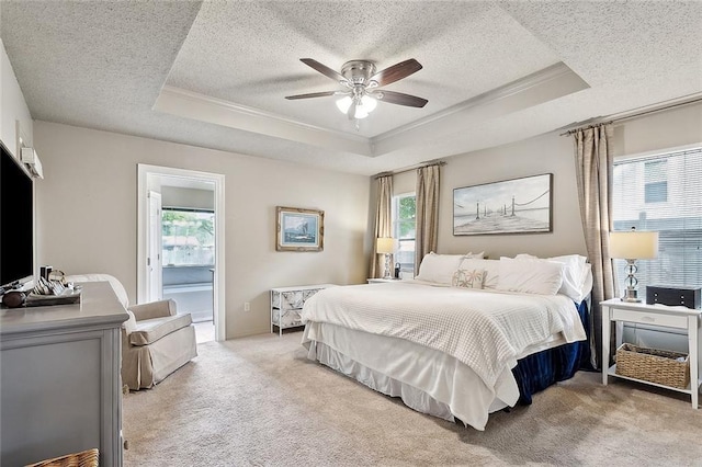 bedroom featuring a raised ceiling, a textured ceiling, light colored carpet, and ornamental molding