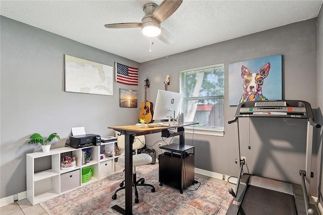 home office with a ceiling fan, baseboards, a textured ceiling, and light tile patterned flooring