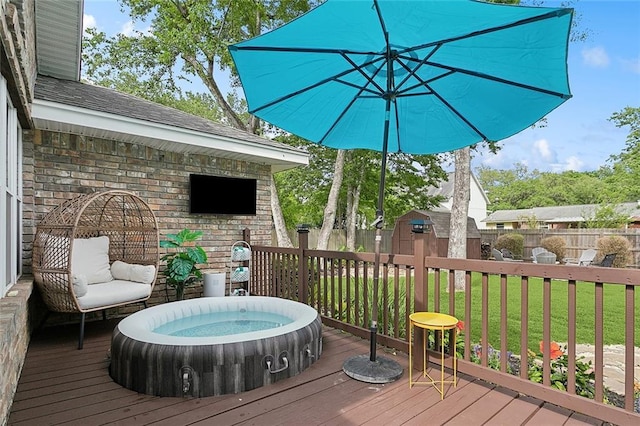 wooden deck featuring a storage shed, an outdoor hot tub, a fenced backyard, an outdoor structure, and a yard