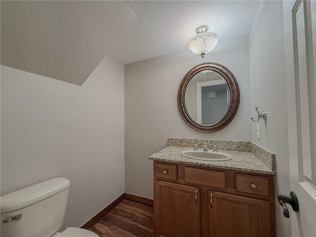 4612 Lorino St, Metairie, LA 70006 - half bathroom featuring toilet, vanity, wood finished floors, and baseboards