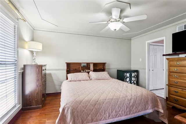 bedroom featuring baseboards, a ceiling fan, wood finished floors, and ornamental molding