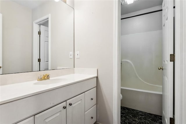 bathroom featuring washtub / shower combination, marble finish floor, and vanity