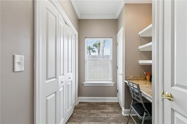 interior space featuring baseboards, ornamental molding, wood tiled floor, and built in desk