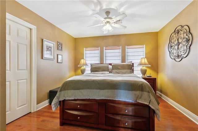 bedroom with wood finished floors, ceiling fan, and baseboards