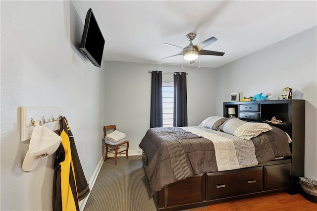 carpeted bedroom featuring baseboards and a ceiling fan